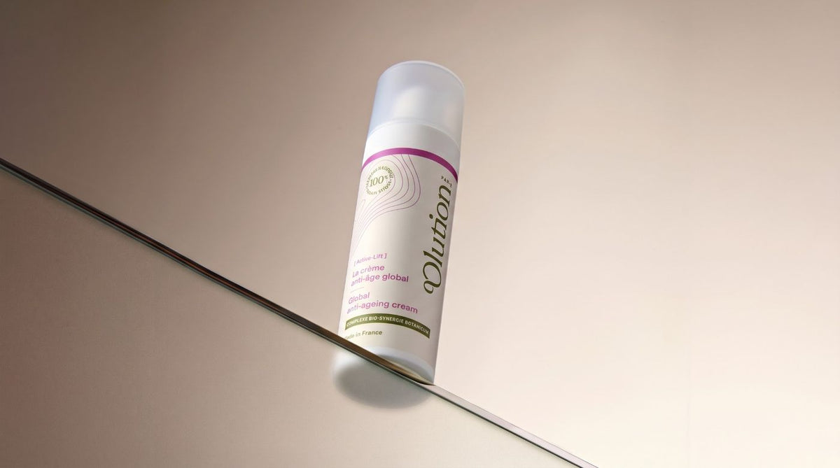 La crème anti-âge global, flacon pompe 30 mL, posée sur une tablette de verre